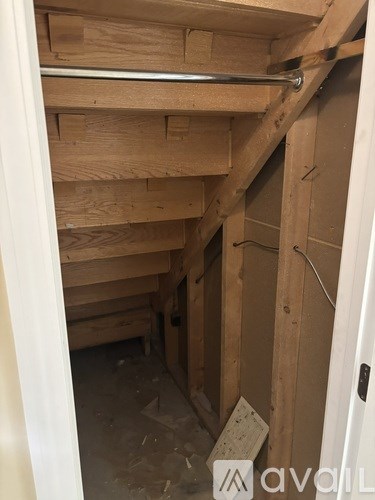 A room under construction with wooden beams and a white door.