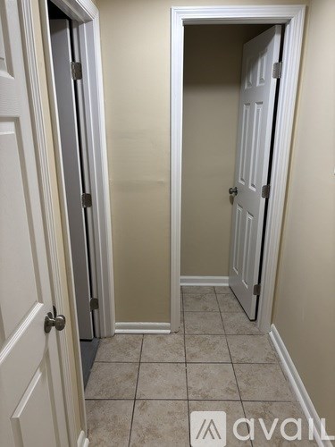 A hallway with two doors, one of which is open.