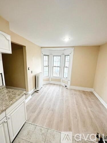A kitchen with a marble countertop and a wooden floor.