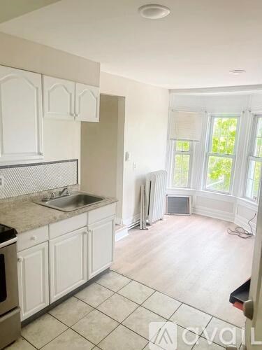 A kitchen with white cabinets and a stainless steel sink.