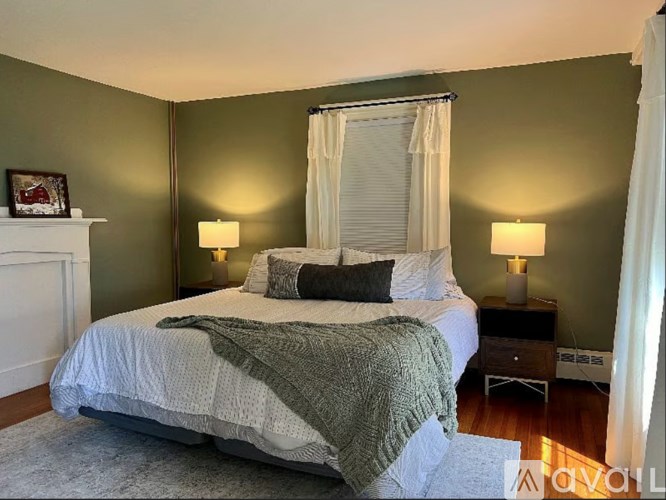 A bedroom with a bed, nightstands, and lamps.