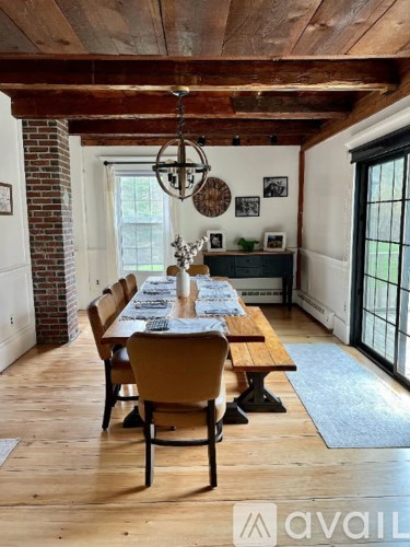 A dining room with a long table and chairs.