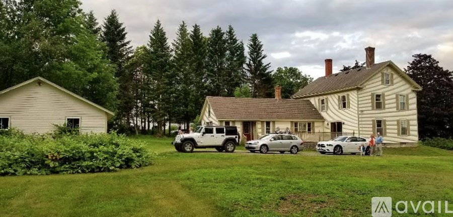 A large house with a car parked in front of it.