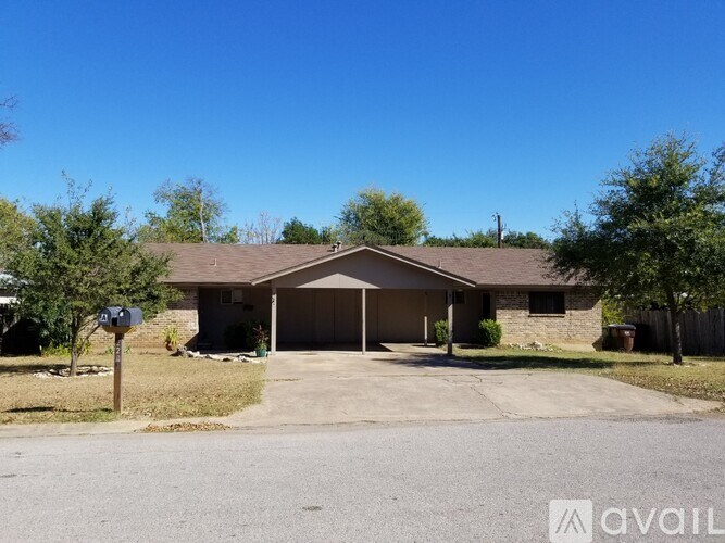 A house with a brown roof and a driveway in front.