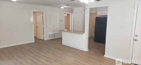 A spacious room with a white counter and a black refrigerator.