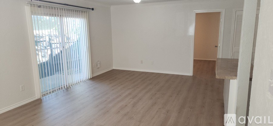 A room with wooden flooring and a sliding glass door.