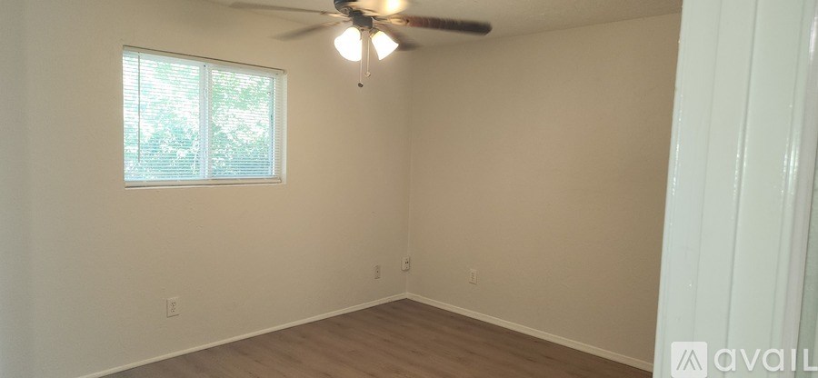 A room with a window and a ceiling fan.
