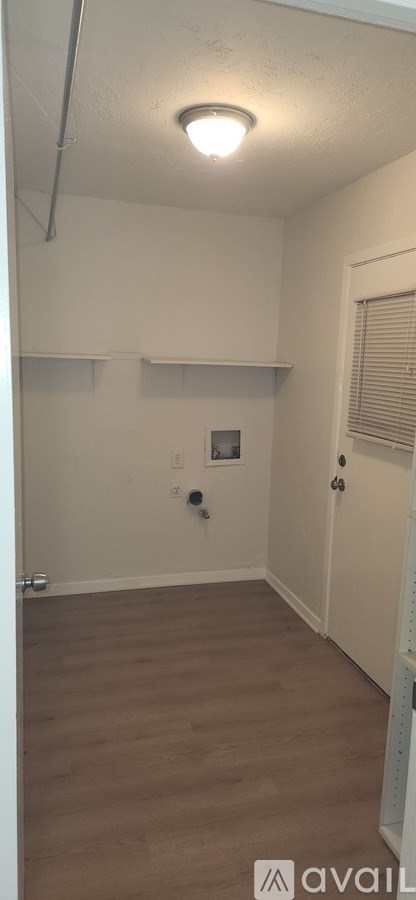 A room with a light on the ceiling and a door on the right.