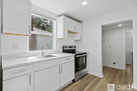 A kitchen with white cabinets and a window.