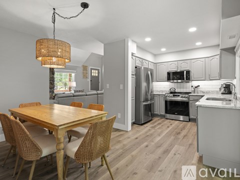 A modern kitchen with a wooden dining table and chairs.
