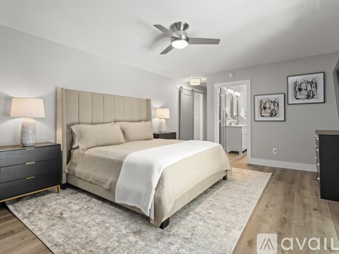 A bedroom with a large bed, a dresser, and a ceiling fan.