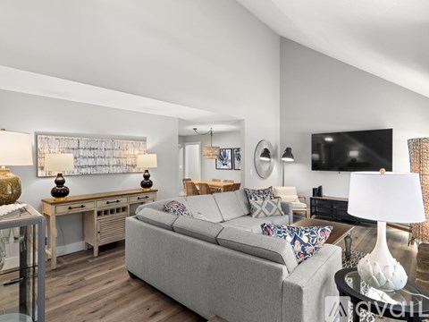 A modern living room with a grey couch and a wooden desk.