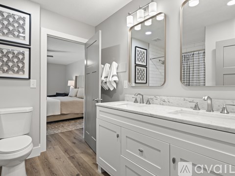 A bathroom with a toilet, sink, and mirror.