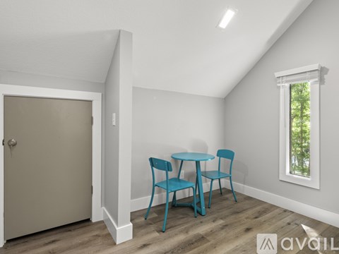 A room with a table and chairs and a window.