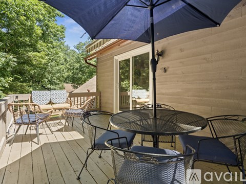 A patio with a table and chairs under an umbrella.