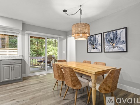 A dining room with a wooden table and chairs.