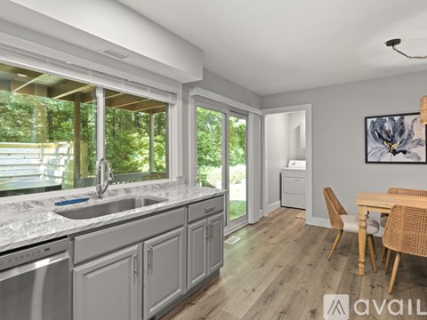 A kitchen with a marble countertop and wooden flooring.