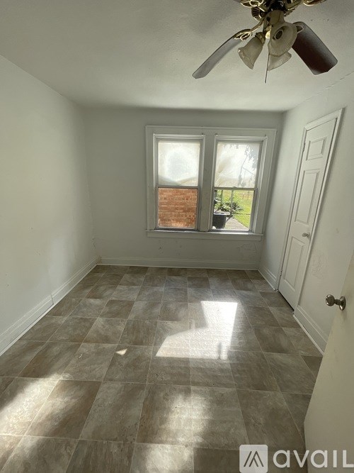A room with a ceiling fan and tiled flooring.