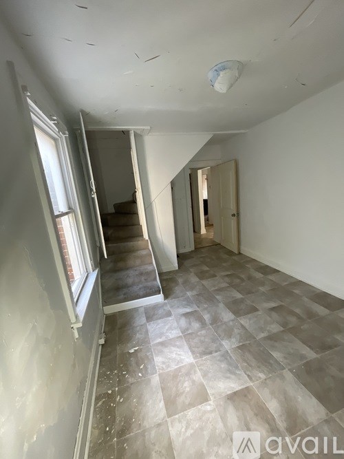 A room with a checkered floor and a staircase.