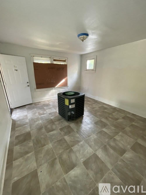 A room with a tiled floor and a window with blinds.