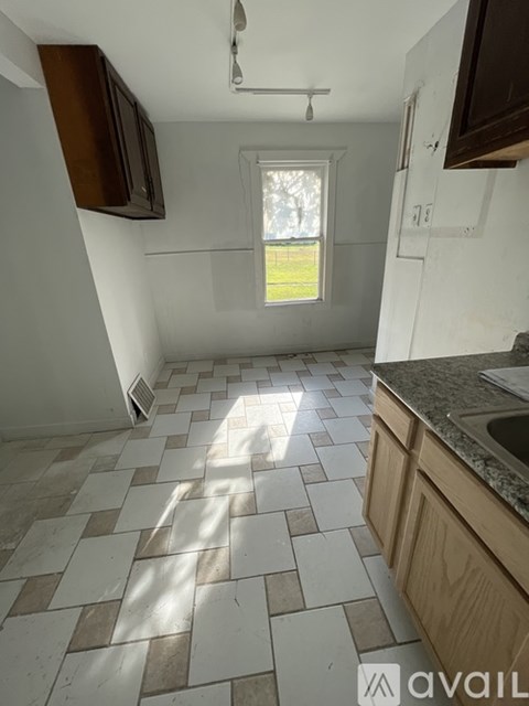 A kitchen with a checkered tile floor and a window.