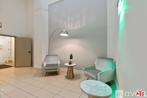 A room with a chair, a table, and a lamp.