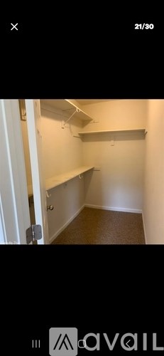 A white door is open to a hallway with a carpeted floor and white walls.