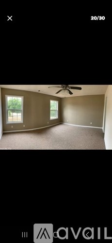 A room with a ceiling fan and two windows.
