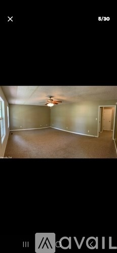 A room with a ceiling fan and a door on the right side.