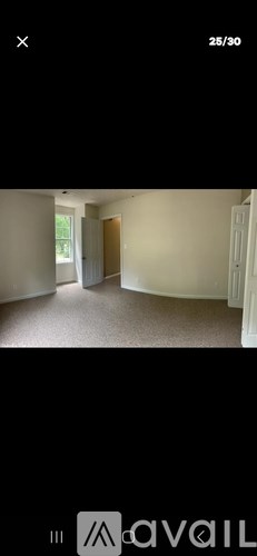 A room with a carpeted floor and a door.