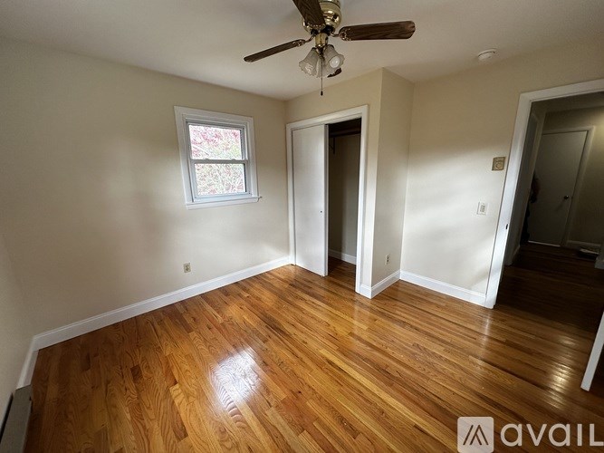 A room with wooden floors and a ceiling fan.