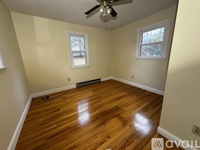 A room with wooden flooring and a ceiling fan.