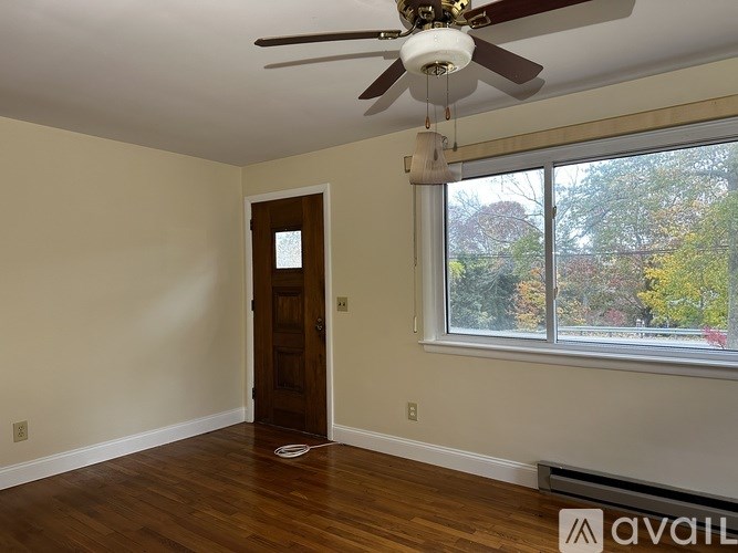 A room with a ceiling fan and a door.