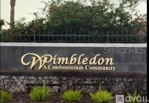 A sign that says "Wimbledon" is displayed in front of a fence.