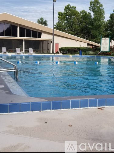 A pool with blue water and a building in the background.
