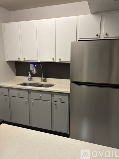 A kitchen with a sink and a refrigerator.