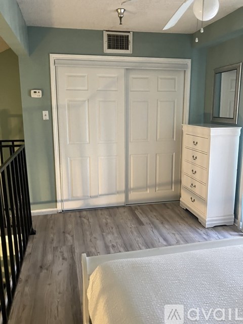 A white door with a white dresser and a white chair in front of it.