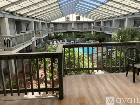 A balcony with a pool in the background.