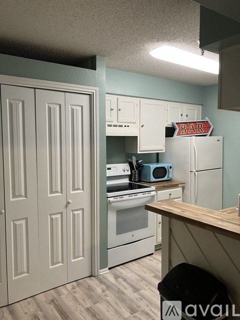 A kitchen with a white oven and cabinets.