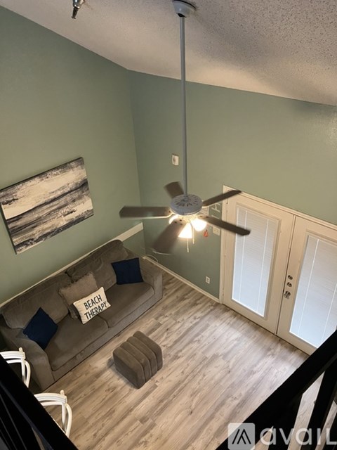 A living room with a couch and a ceiling fan.