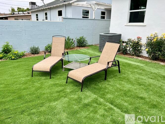Two chairs and a table are on a lawn.