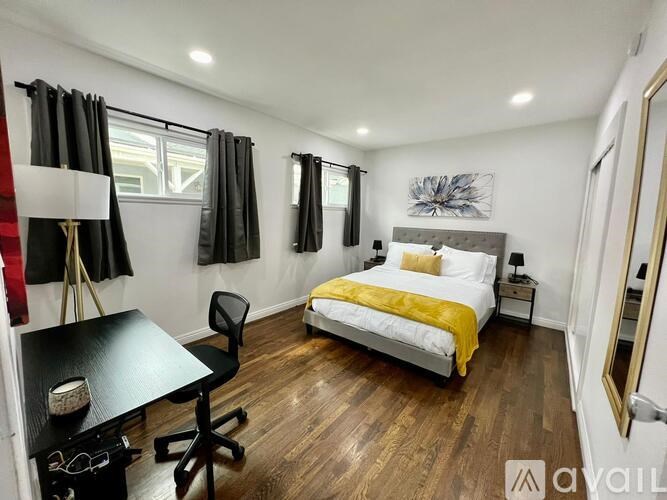 A bedroom with a bed, desk, and chair.