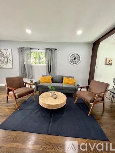 A living room with a couch, two chairs, and a coffee table.
