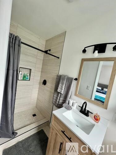 A bathroom with a white sink and a mirror.