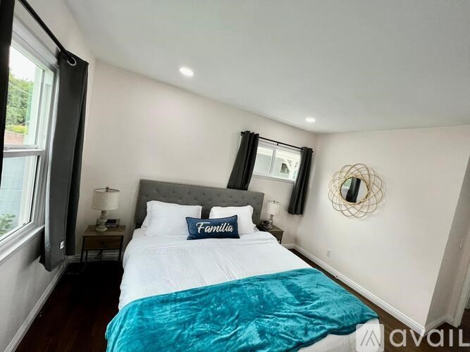 A bedroom with a bed, nightstands, and a mirror on the wall.