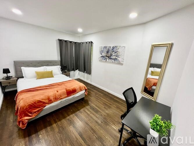 A bedroom with a bed, desk, and chair.