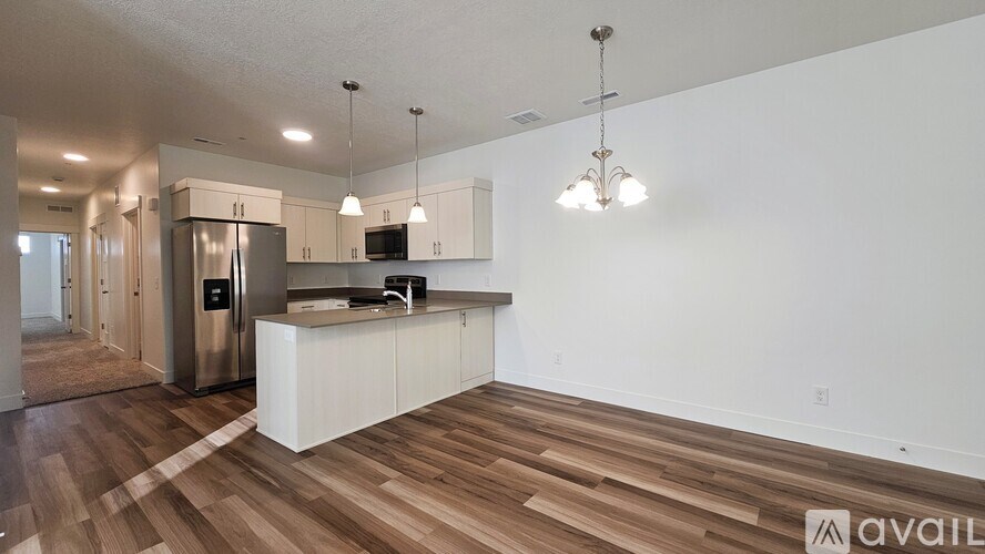 A kitchen with white cabinets and a wooden floor.