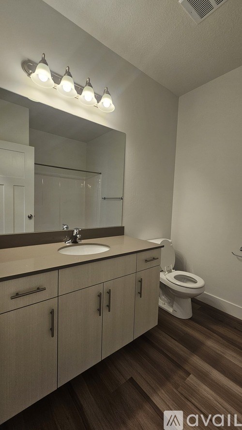 A bathroom with a sink, mirror, and toilet.