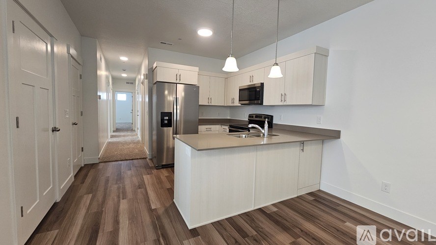 A kitchen with white cabinets and a wooden floor.
