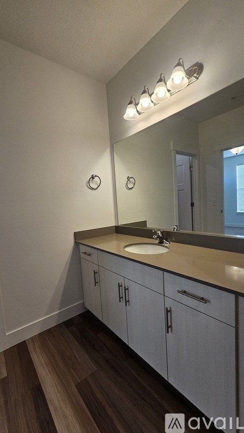 A bathroom with a sink, mirror, and lights.